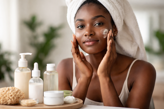Realistische Darstellung einer Frau mit dunkler Haut, die sanft eine beruhigende Feuchtigkeitspflege im Badezimmer aufträgt, mit minimalistischen Pflegeprodukten im Vordergrund, Fokus auf Hautbarriere-Pflege, ohne Text im Bild.