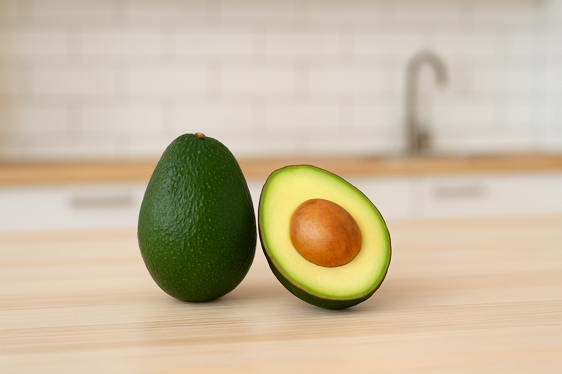 Ganze und halbierte Avocado auf einem hellen Holztisch in einer modernen Küche – Symbol für gesunde Ernährung und natürliche Hautpflege.
